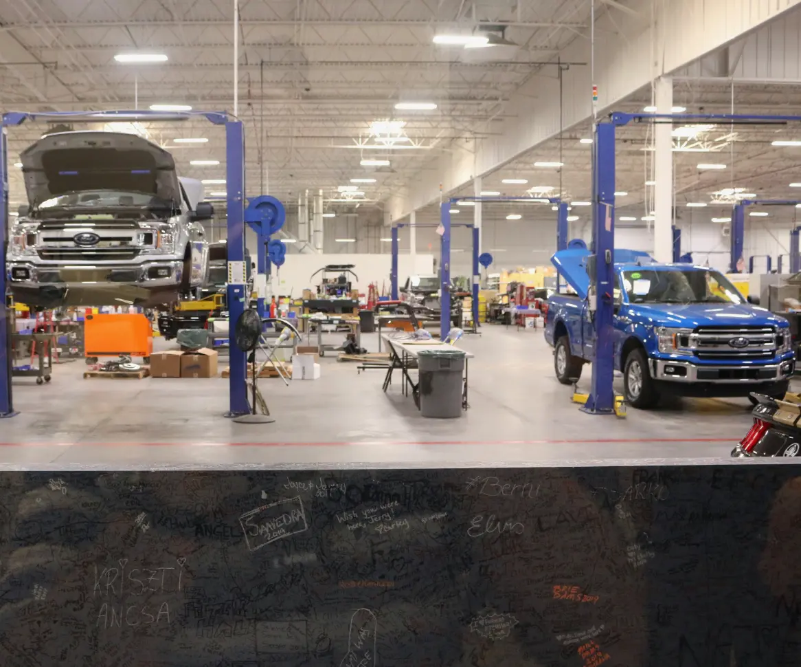 Zwei Pick-ups werden in einem Werk von Ford gebaut und befinden sich auf einer Hebebühne