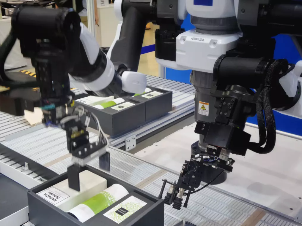 Roboter packen Waren in einen Karton auf einer Förderstraße