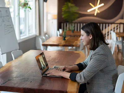 Ein Digital Human Resource Manager sitzt an einem Tisch und nutzt einen Laptop.