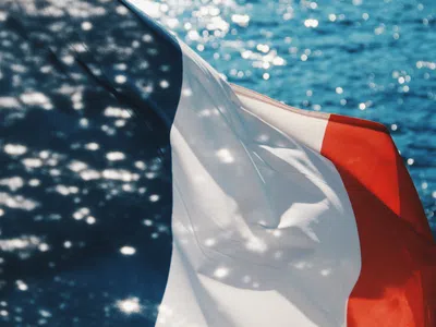 Französische Flagge weht vor dem Meer im Wind
