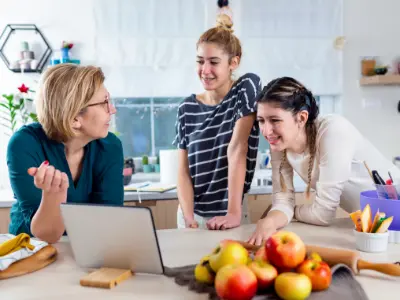 Eine Gruppe von Frauen, die Ernährungswissenschaften (B.Sc.) studieren, steht um einen Laptop herum.