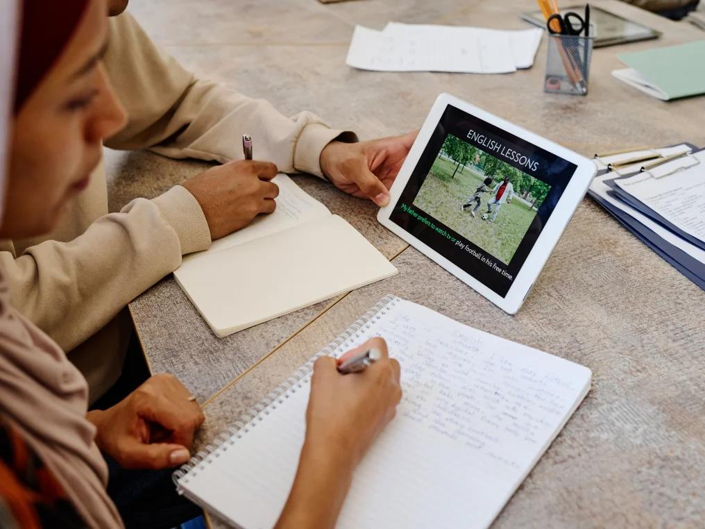 Zwei Personen nehmen über ein Tablet an Unterrichtsstunden in Englisch teil
