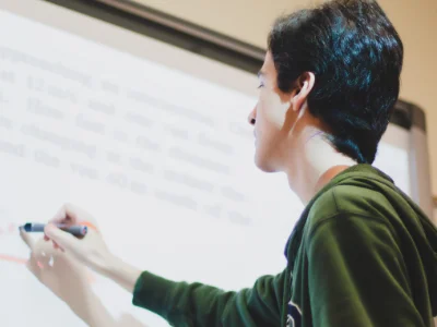 Schüler schreibt einen englischen Satz an die Tafel