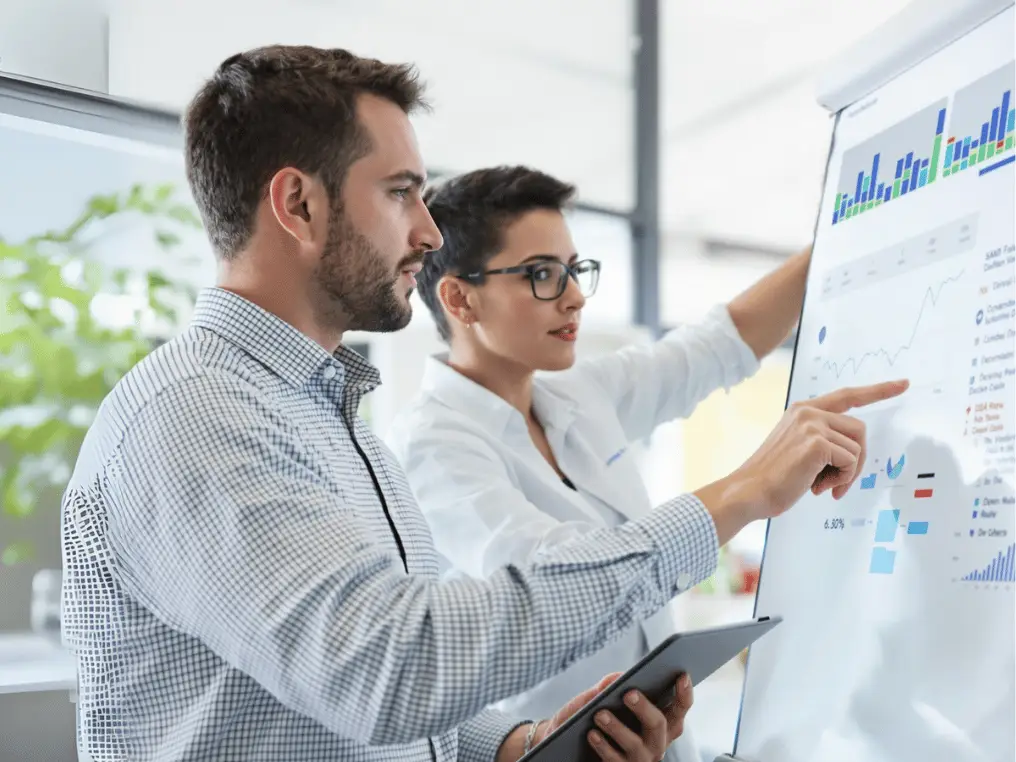 Ein Data Science-Student sitzt vor seinem Laptop und sein Betreuer schaut ihm über die Schulter.  