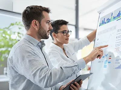 Ein Data Science-Student sitzt vor seinem Laptop und sein Betreuer schaut ihm über die Schulter.  