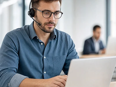 Mitarbeiter bearbeitet Geschäftskorrespondenz am Laptop.