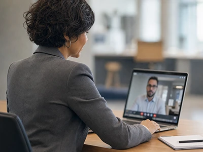 Mitarbeiterin führt ein Videogespräch am Laptop.
