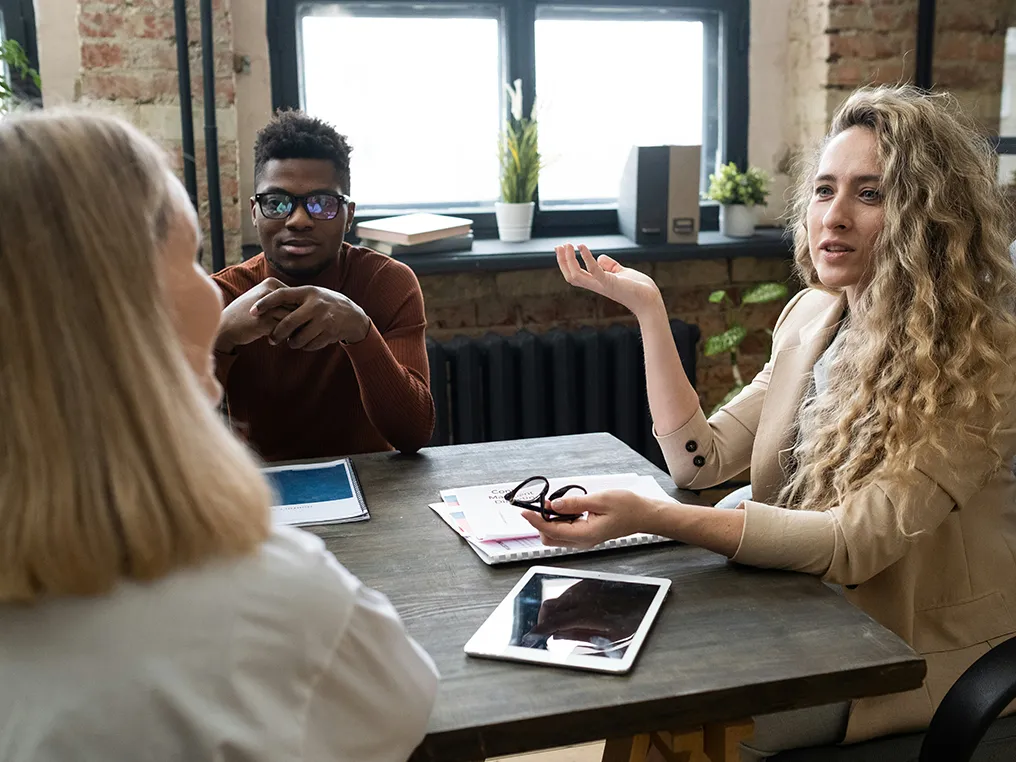 Die Gruppe von Personen diskutiert intensiv in einer professionellen Büroumgebung.
